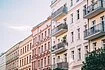 Row of white, sand, pink and yellow colored Prenzlauer Berg apartment buildings in Berlin.